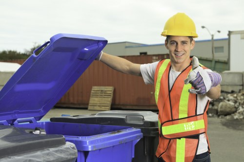 Worker placing waste into a skip